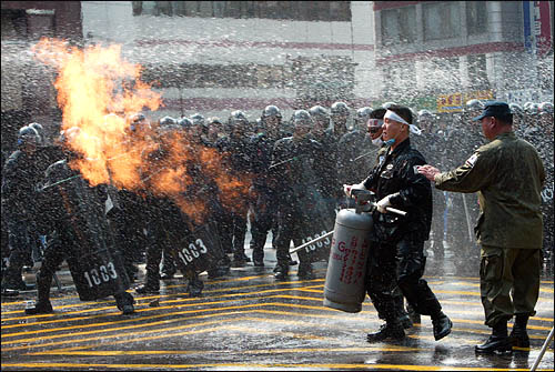지난 2002년 9월 설악동지회 회원들이 가스통에 불을 붙여 경찰들을 위협하고 있다.